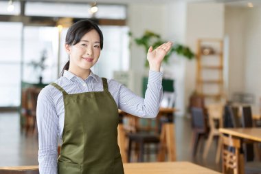 Bir bayan restoran çalışanı mağazayı gezdiriyor.