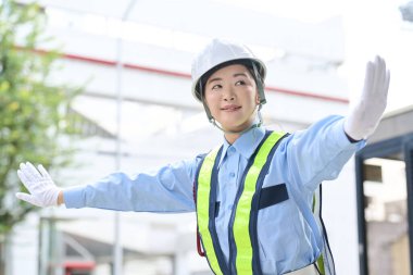 Asyalı kadın güvenlik görevlisi olarak çalışıyor.