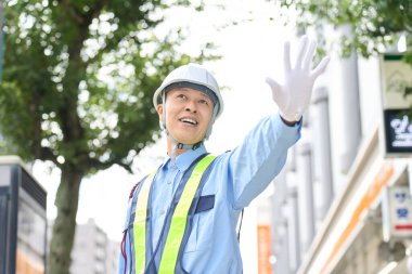 Güvenlik görevlisi olarak çalışan Asyalı bir adam.