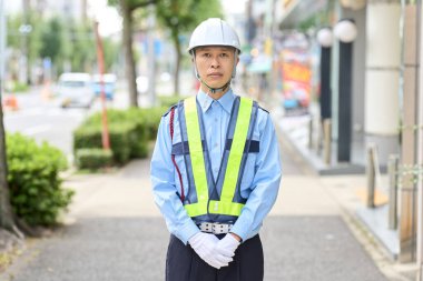 Güvenlik görevlisi olarak çalışan Asyalı bir adam.