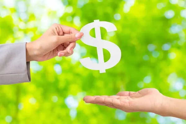 stock image Hand of a woman handing over white paper shaped like money