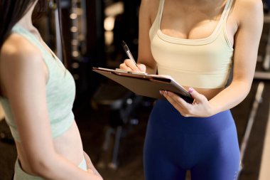 Spor salonunda kadın eğitmen danışmanlık yapıyor.