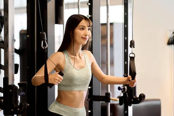 A woman training her upper body with a cable machine