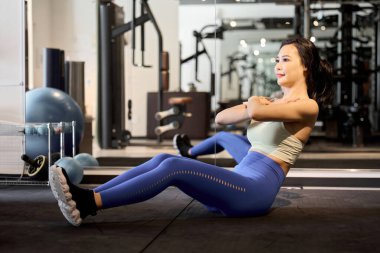 Karın kaslarını mekik ile çalıştıran bir kadın.