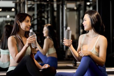 Spor salonunda gülümseyen ve konuşan bir kız stajyer.