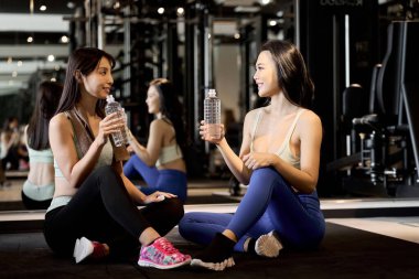 Spor salonunda gülümseyen ve konuşan bir kız stajyer.