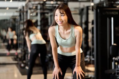 Spor salonunda nefes alan bir kadın.
