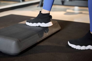 Bacaklarını bir platformda çalıştıran bir kadın.