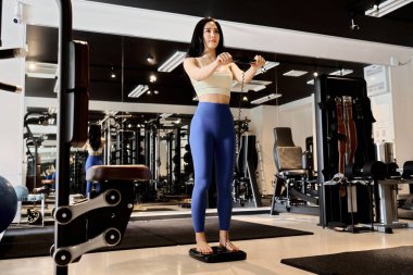 Spor salonunda vücut yağı kullanan bir kadın.