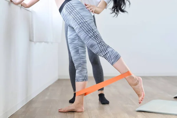 A woman doing lower body training using a resistance band