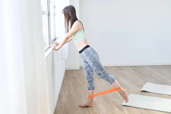 A woman doing lower body training using a resistance band