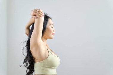 Bir kadın vücudunun üst kısmını geriyor.