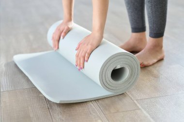 Yoga minderi seren bir kadının elleri.