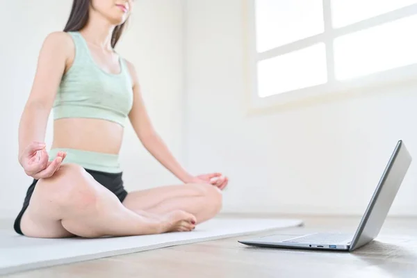 A woman taking online yoga lessons