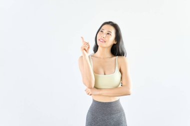 Spor kıyafetleri giymiş bir kadın işaret ediyor.