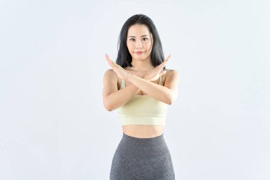 Spor giysili bir kadın NG işareti veriyor.