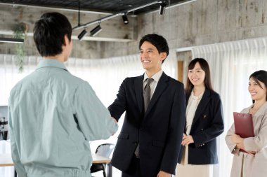 İşadamı ve işçi ofiste el sıkışıyor.