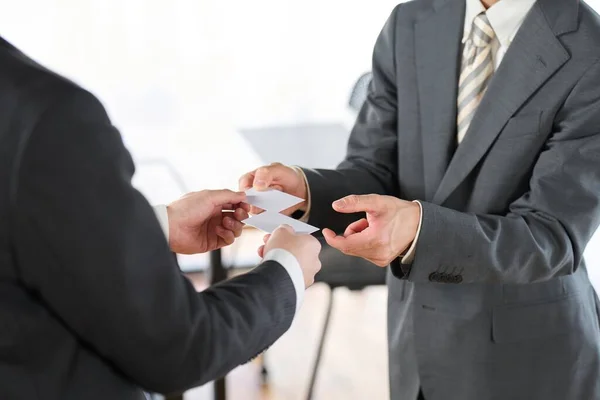 Hands of businessmen exchanging business cards