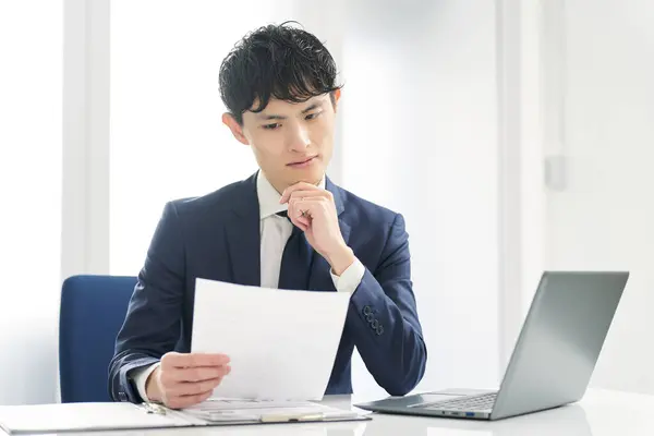 Asian Businessman Examining Work Documents — Stock Photo, Image