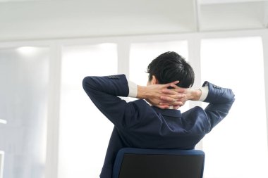 Çalışırken düşünen bir iş adamının arka görünüşü