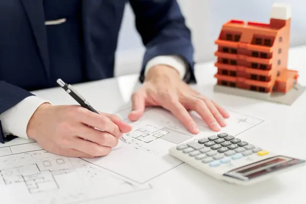 Businessman calculating the floor plan of an apartment