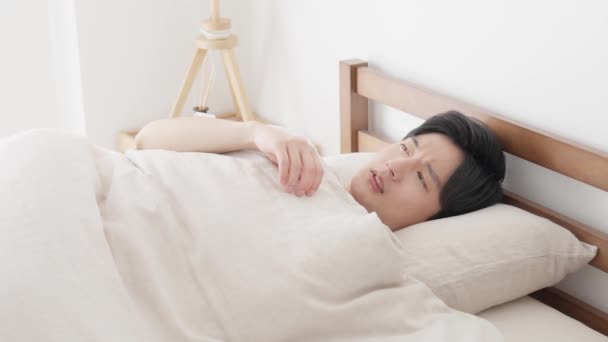 Ένας Άντρας Μετράει Θερμοκρασία Του Ένα Θερμόμετρο Ενώ Κοιμάται — Αρχείο Βίντεο