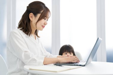 Çocuk yetiştirirken evden çalışan bir kadın.