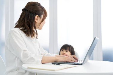 Çocuk yetiştirirken evden çalışan bir kadın.