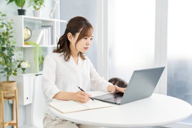 Çocuk yetiştirirken evden çalışan bir kadın.