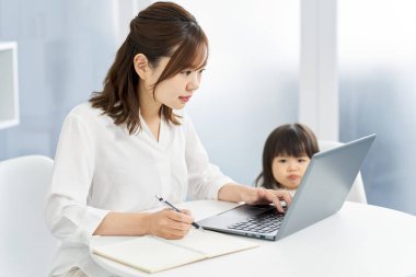 Çocuk yetiştirirken evden çalışan bir kadın.