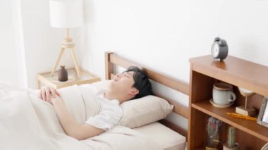 Bir adam çalar saati durdurur.