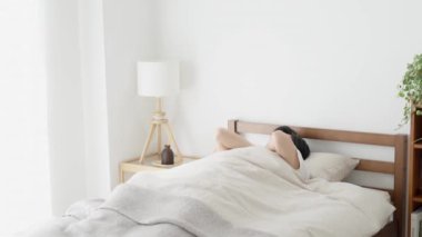 Bir adam uyanıyor ve esniyor.