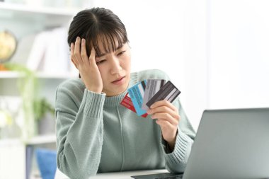 Kredi kartı seçmekten korkan bir kadın.