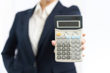 Hesap makinesiyle hesap yapan öfkeli bir kadın.