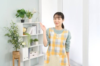 Önlük takan bir kadın yol gösteriyor.