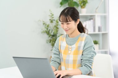 Bilgisayarda çalışan önlük giyen bir kadın.