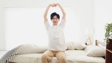 Bir adam uyanıyor ve esniyor.