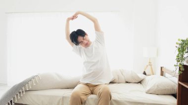 Bir adam uyanıyor ve esniyor.