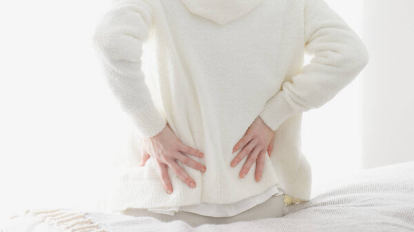 Женщина заботится о своей больной нижней части спины