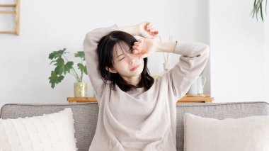 Uykulu gözlerini ovuşturan bir kadın