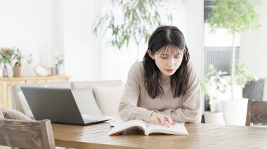 A woman studying for a qualification at home clipart