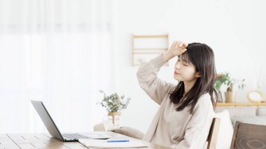 Bilgisayarda çalışan bir kadının başı ağrıyor.