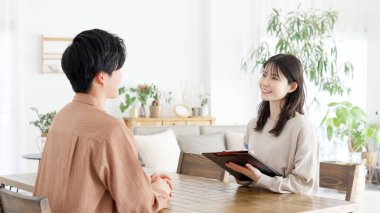 Asyalı bir kadın bir adamla röportaj yapıyor.