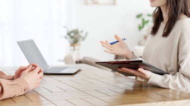 Asyalı bir kadın bir adamla röportaj yapıyor.