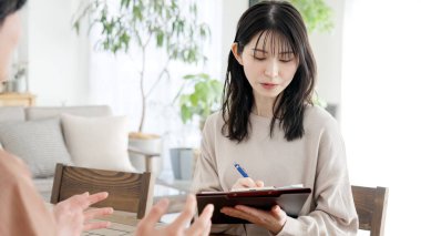 Asyalı bir kadın bir adamla röportaj yapıyor.