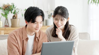 Couples browsing real estate and travel sites clipart