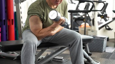 Man training his arms with dumbbell arm curls clipart