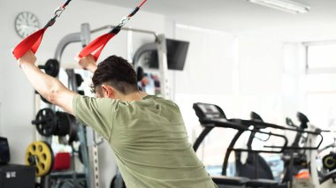 Askıya alma eğitimiyle karnını güçlendiren bir adam.