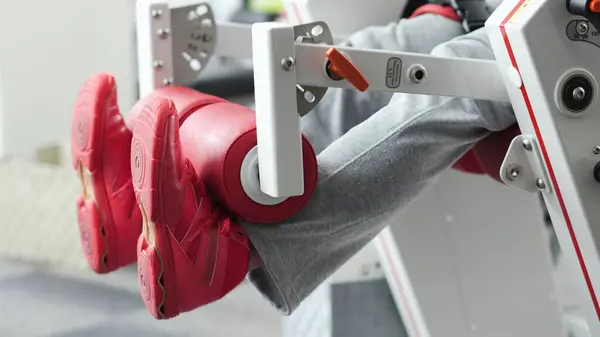 stock image Man exercising his legs with leg extensions