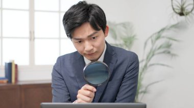 Büyüteçle araştırma yapan bir iş adamı.